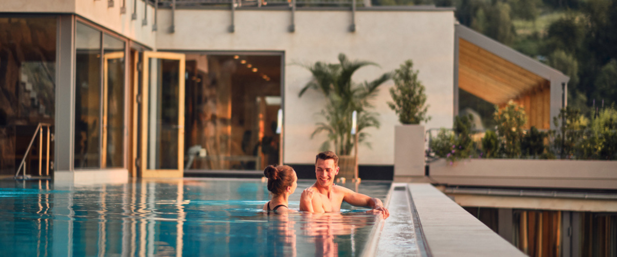 Paar badet im Infinity Außenpool den Hotel Deimann