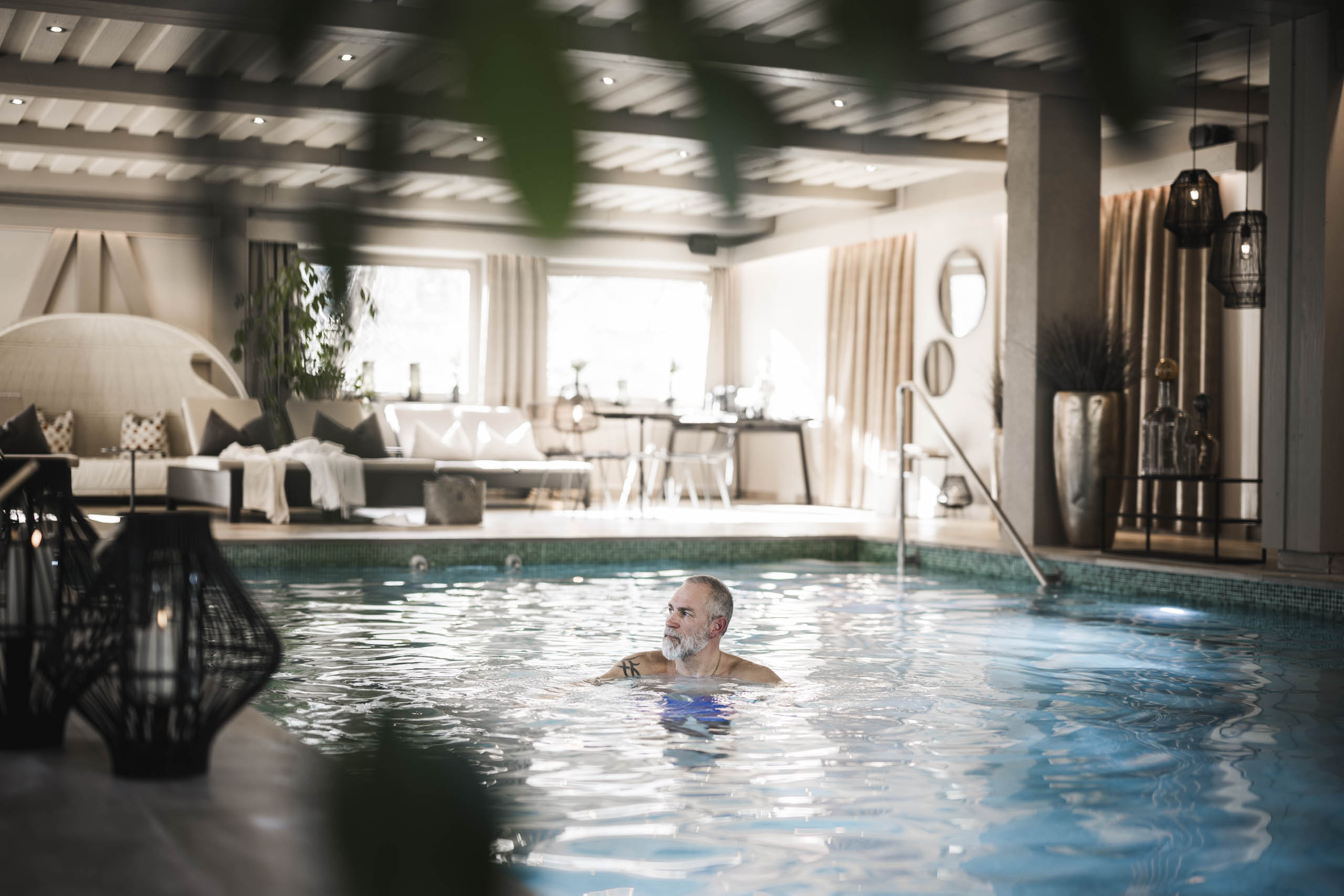 Mann schwimmt im Innenpool des Hotel Stafler